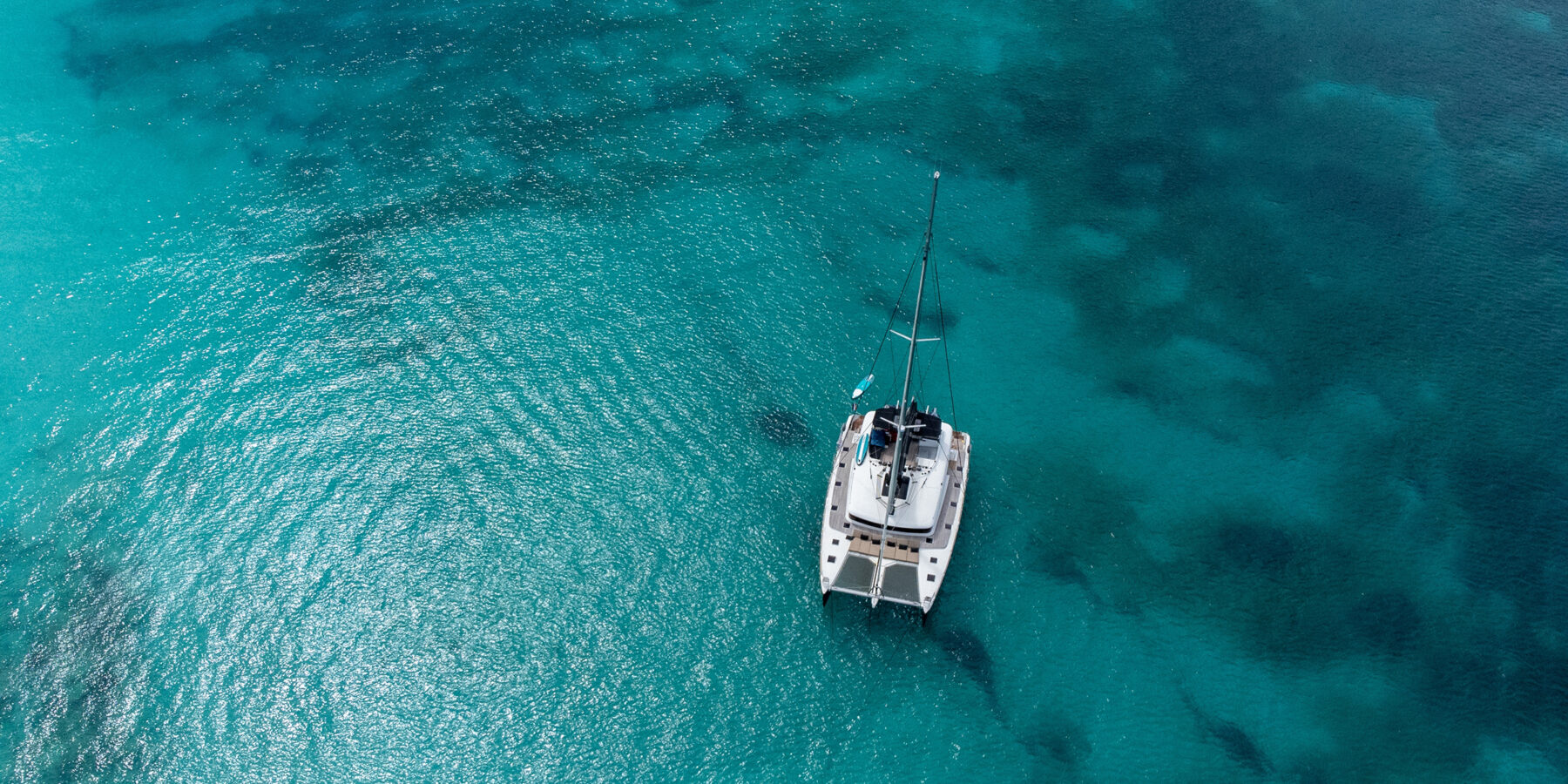 Small,Catamaran,In,The,Middle,Of,The,Blue,Sea,Of